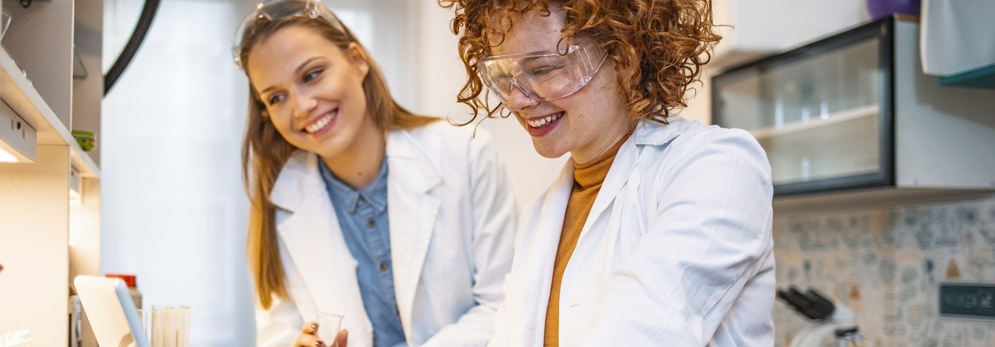 Zwei Wissenschaftlerinnen arbeiten im Labor an einem Laptop. Copyright: AdobeStock