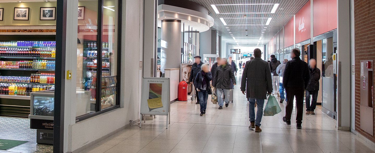 Blick in die Ladenpassage im zentralen MHH-Bettenhaus. Menschen laufen den Flur entlang.