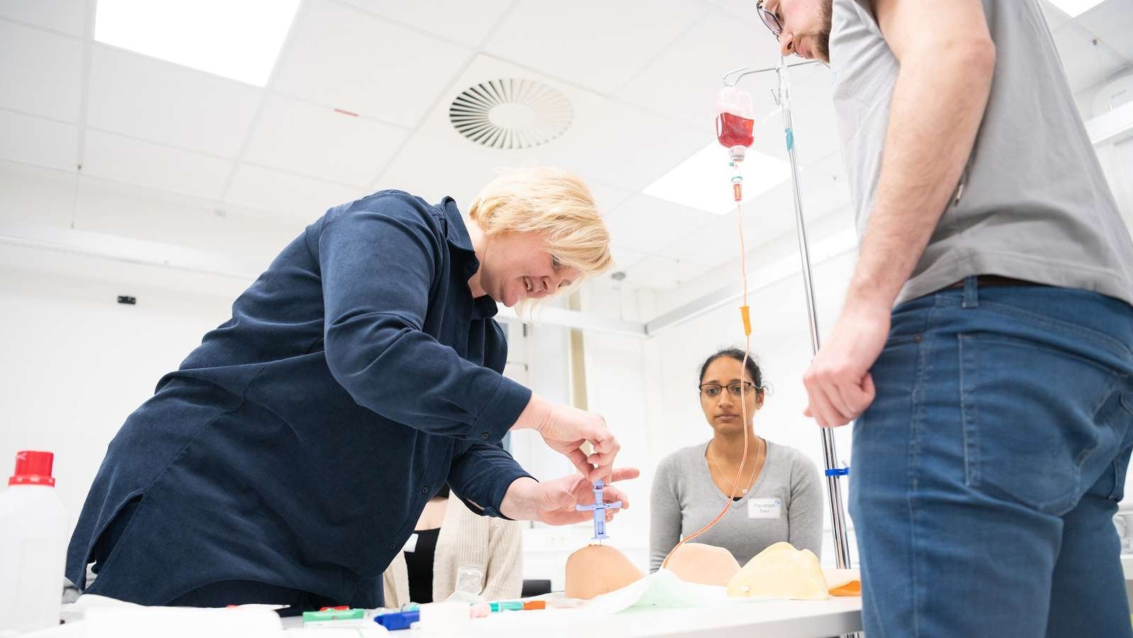 A nurse at a bone marrow puncture simulator.