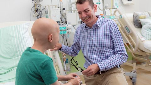 Professor Kratz spricht mit einem jungen Patienten in der Kinderklinik. 