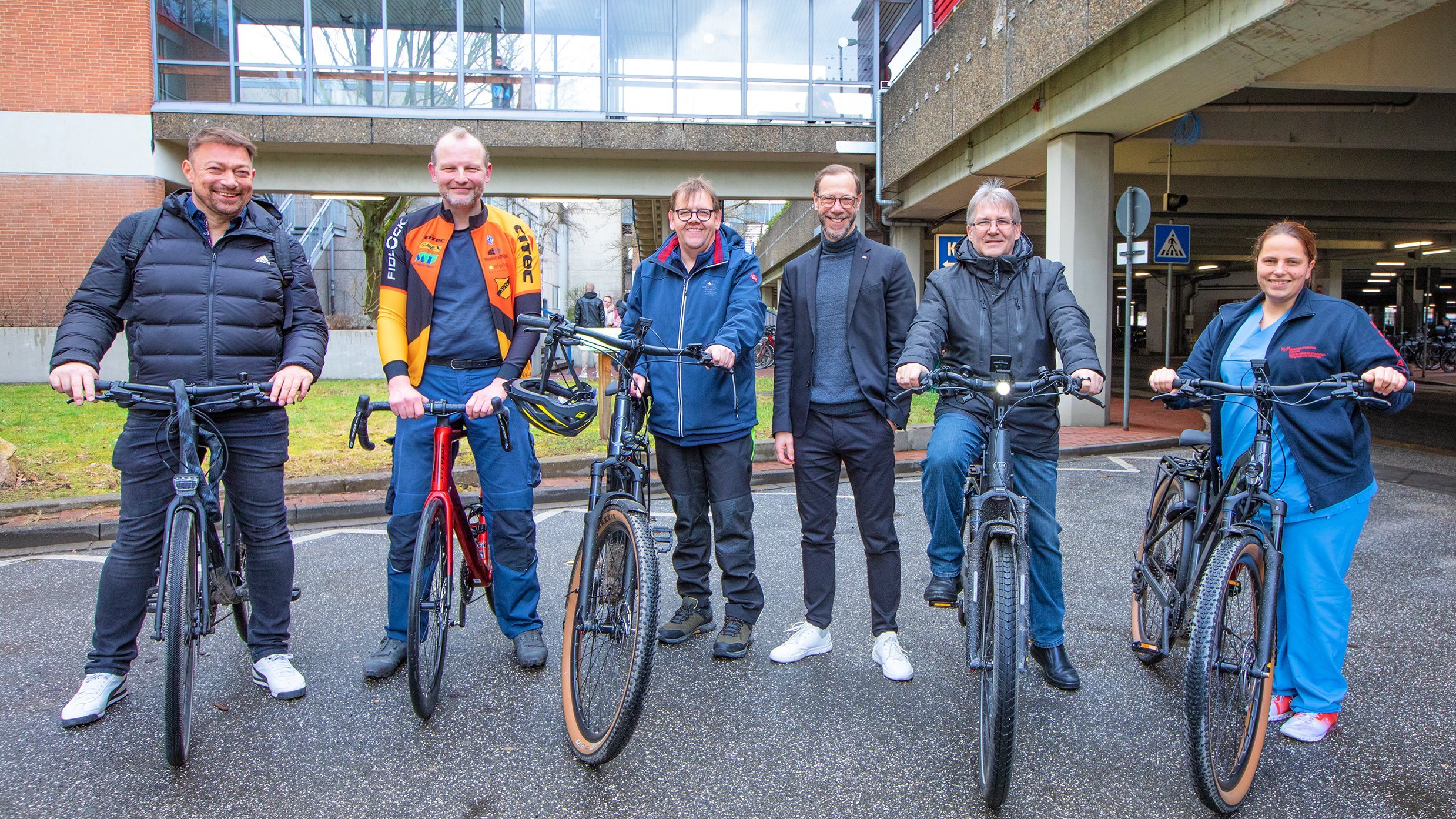 Jörg Stühmeier (centre) with five MHH employees who have a bicycle next to them.