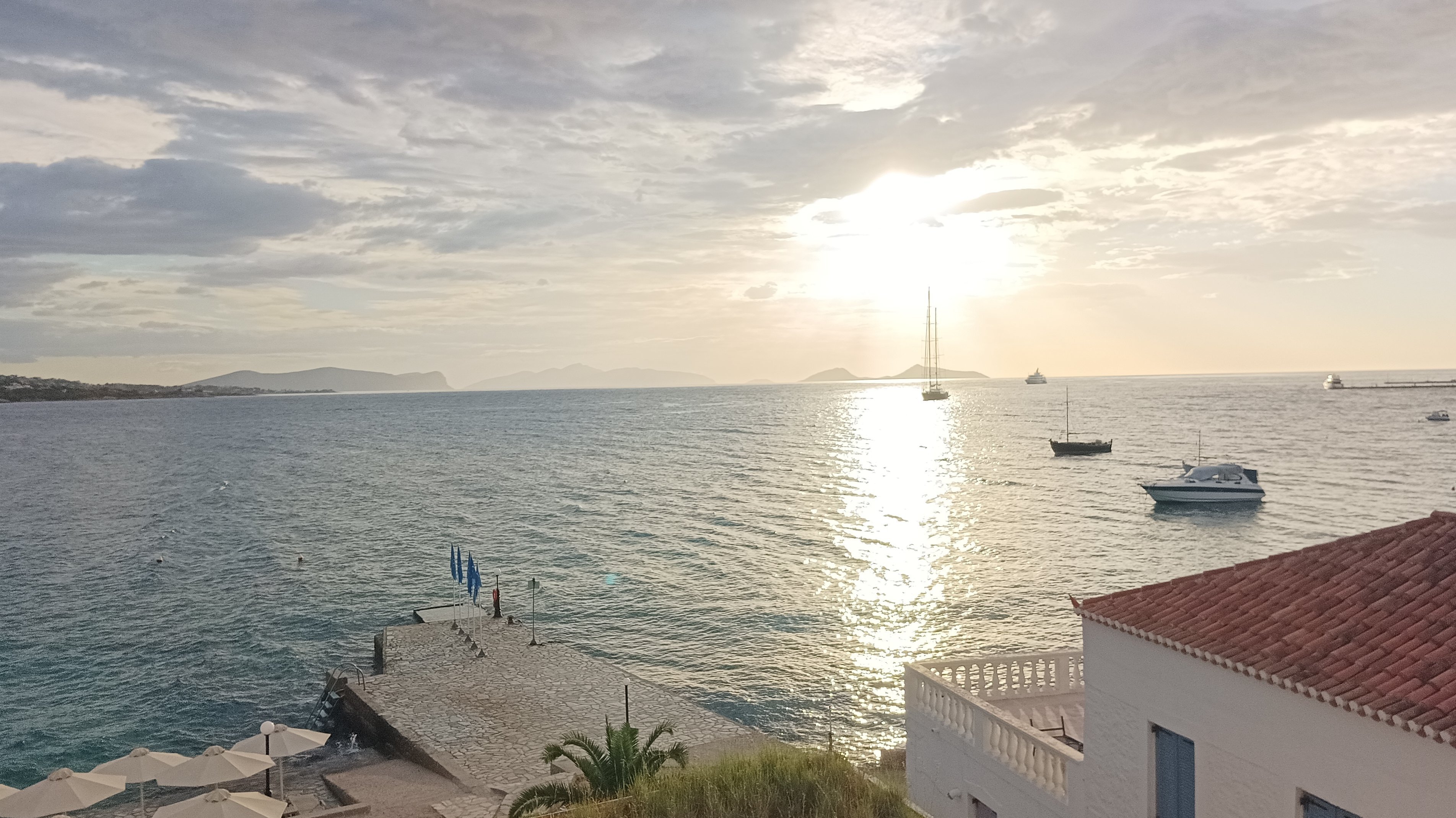 Blick aufs Meer, im Vordergrund ist ein typisch griechisches, weiß-blaues Haus zu sehen.