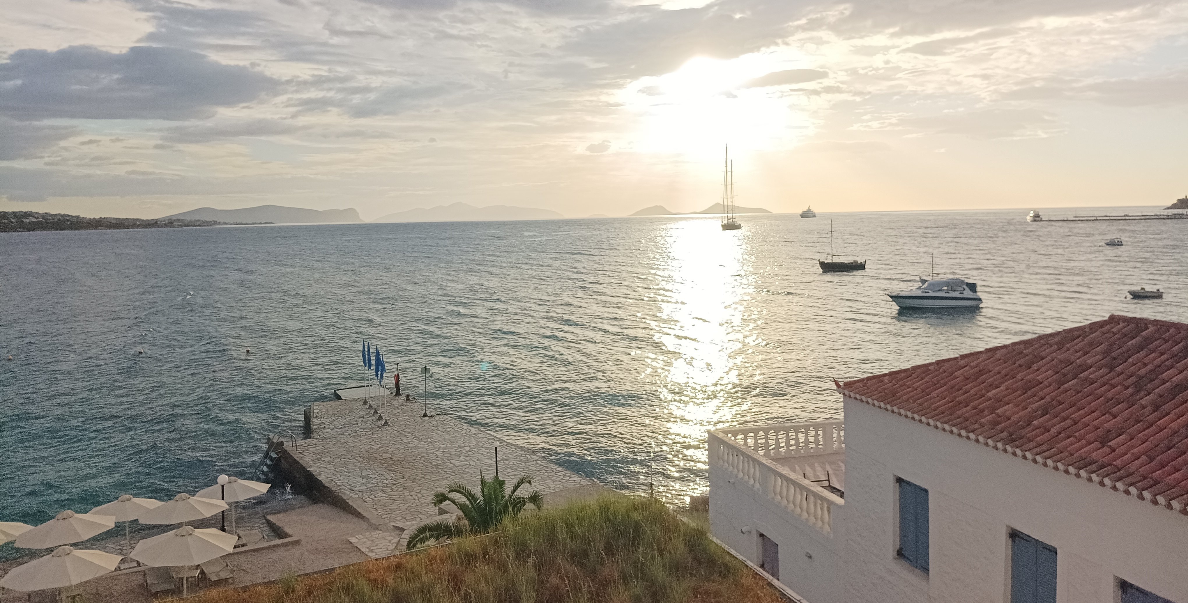 Blick aufs Meer, im Vordergrund ist ein typisch griechisches, weiß-blaues Haus zu sehen.