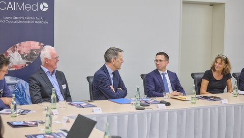 Wolfgang Nejdl, Falko Mohrs, Dr. Georg Schütte und Prof. Dr. Denise Hilfiker-Kleiner sitzen nebeneinander in einem Konferenzraum