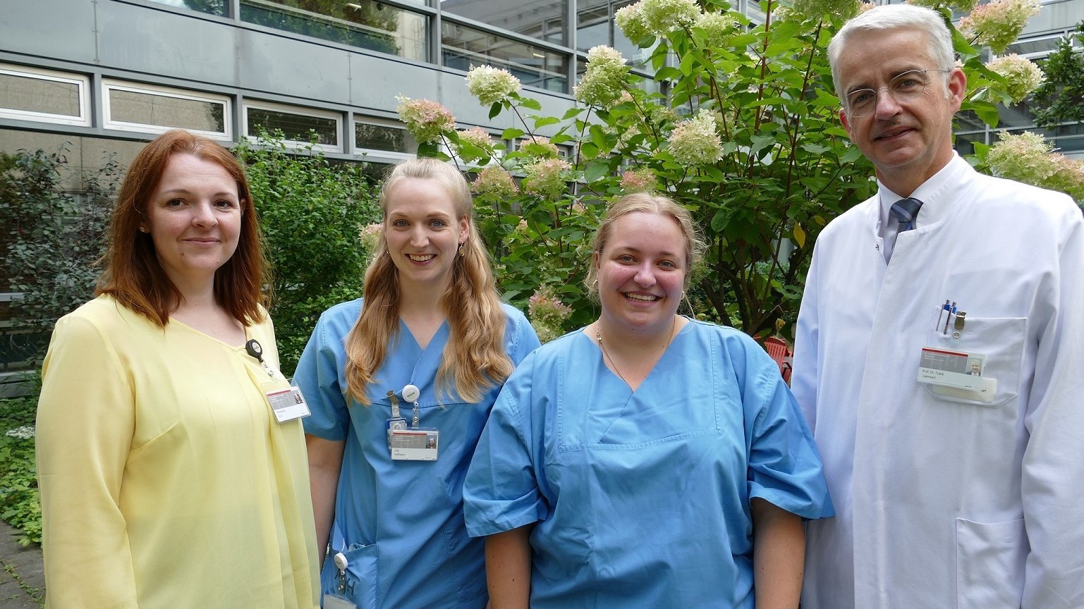 The two MFA trainees Victoria Minch (22) and Lilly Hoffmann (25) are standing next to each other, with MHH Vice President Frank Lammert and Miroslawa Kurt from the MFA training centre standing to their left and right.