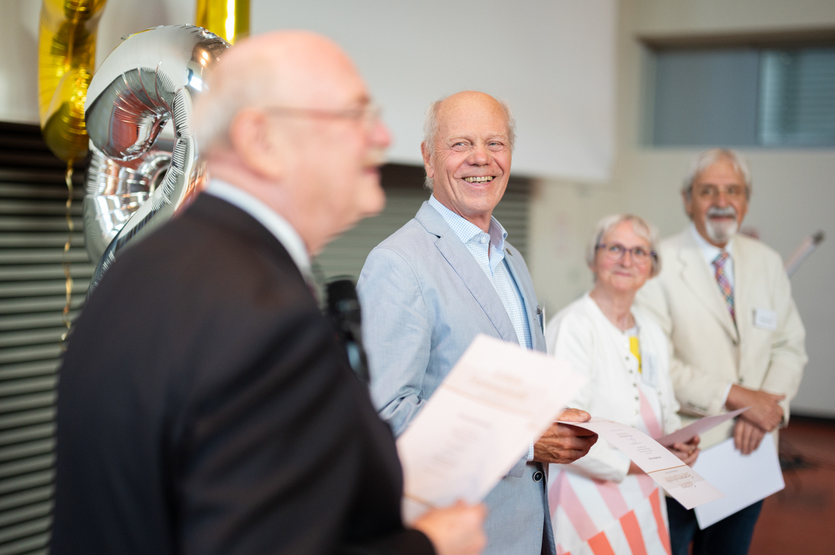 Professor Manns übergibt die goldenen Examensurkunden.