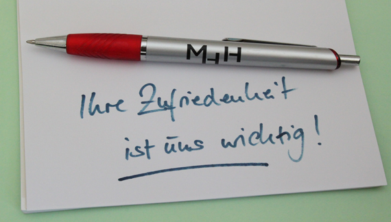 MHH-Kuli auf Schriftzug: Ihre Zufriedenheit ist uns wichtig!