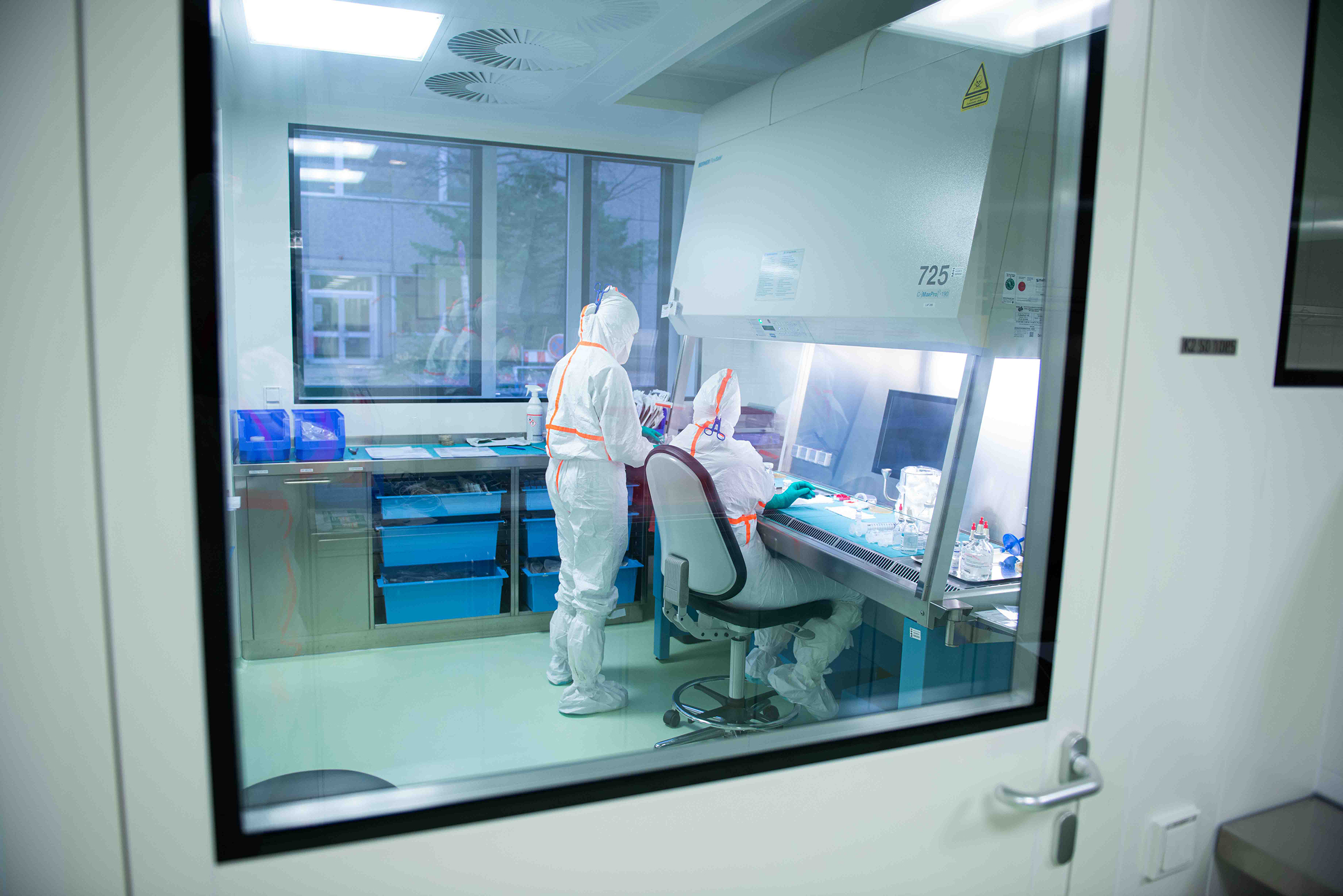 Two people in white protective suits in a laboratory.