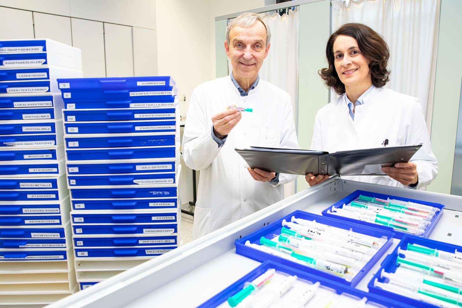 A doctor with blue boxes in his hand.